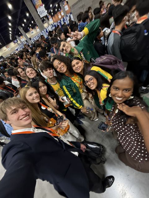 Evan Morris taking a group photo with international finalists in the exhibit hall at Regeneron ISEF