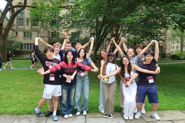 Evan Morris and Yale Young Global Scholars classmates spelling out a Y with their arms on a Yale quad